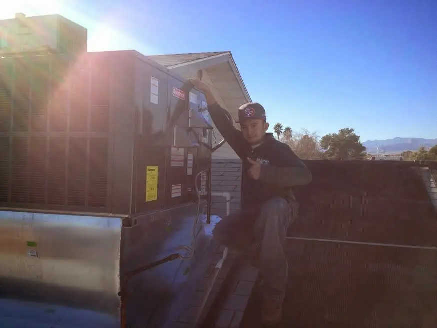 HVAC technician performing AC Tune-Up on a rooftop unit in Marcellus